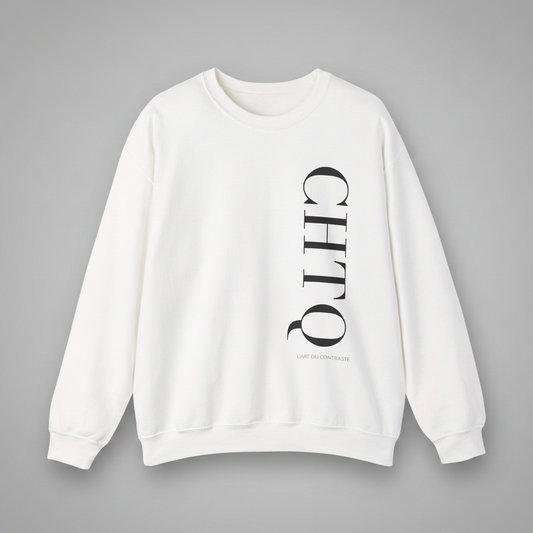 A white crewneck sweatshirt with a vertical black CHTQ graphic and smaller L’Art du Contraste text on the front, displayed against a neutral gray background.