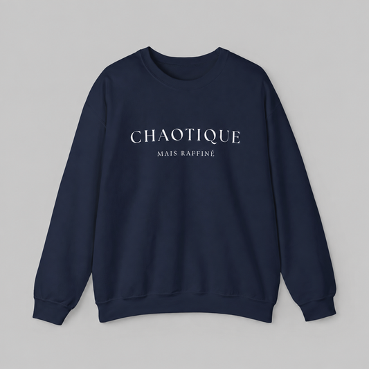 Navy blue sweatshirt on a white background featuring a “Chaotique Mais Raffiné” graphic text print.