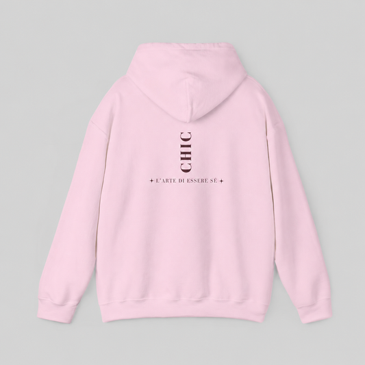 A light pink pullover hoodie featuring a dark brown vertical CHIC back graphic and French-inspired typography, photographed from behind against a clean light gray studio background.