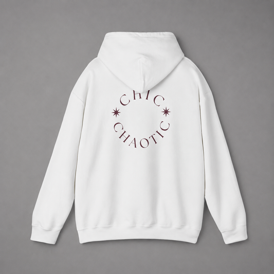 White pullover hoodie shown from the back, featuring a dark burgundy circular CHIC CHAOTIC graphic with subtle star accents against a neutral gray studio background.
