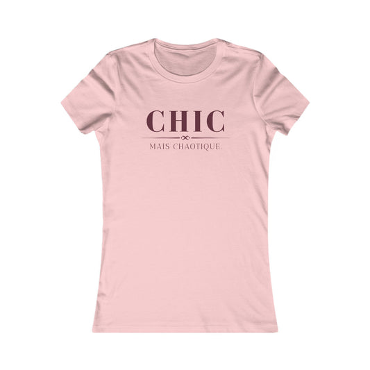 A light pink short-sleeve crewneck t-shirt with the French phrase 'CHIC MAIS CHAOTIQUE' printed in dark pink on the chest, displayed on a clean white background.