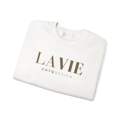 A folded white crewneck sweatshirt with 'LA VIE' printed in a muted olive-brown serif font and 'CHTQDESIGN' in smaller sans-serif text below, shown on a clean white background.