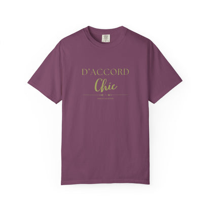 A purple short-sleeve crewneck t-shirt with 'D'ACCORD Chic' printed in gold on the chest, displayed on a clean white background.