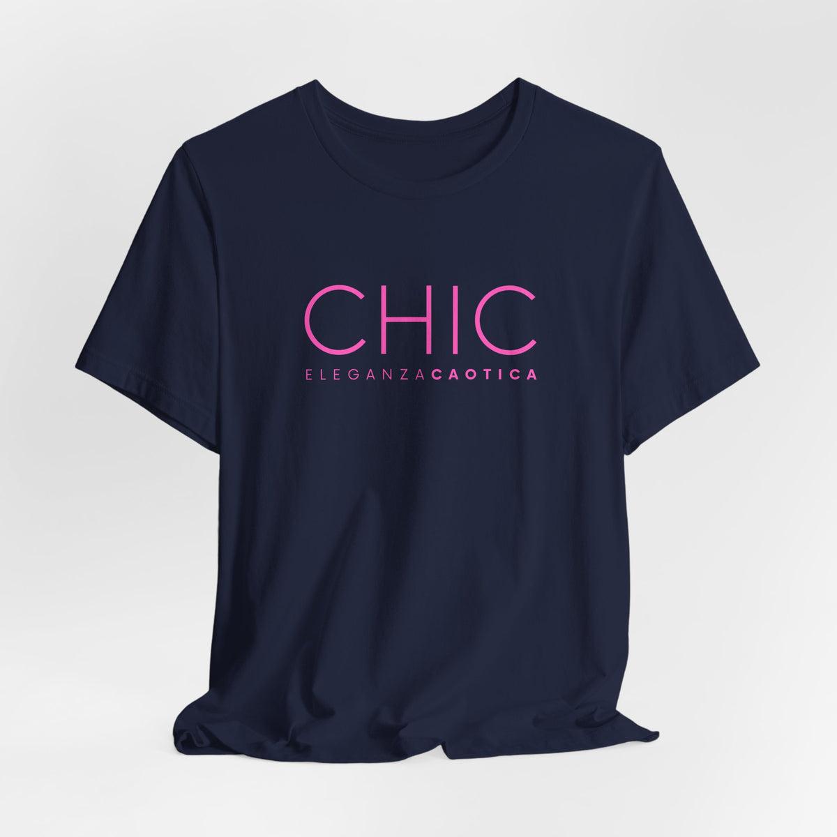 Navy blue graphic T-shirt with pink 'CHIC ELEGANZA CAOTICA' typography on a neutral gray studio background.