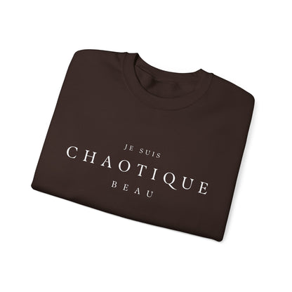Folded brown crewneck sweatshirt with the text 'JE SUIS CHAOTIQUE BEAU' printed in white across the chest