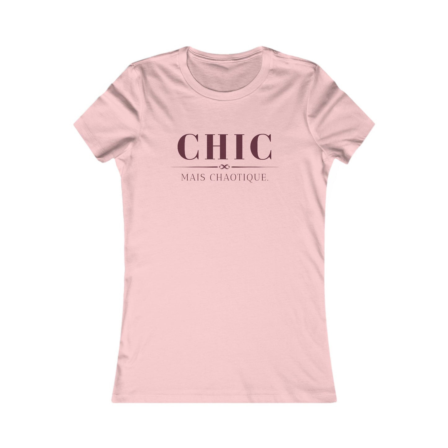A light pink short-sleeve crewneck t-shirt with the French phrase 'CHIC MAIS CHAOTIQUE' printed in dark pink on the chest, displayed on a clean white background.