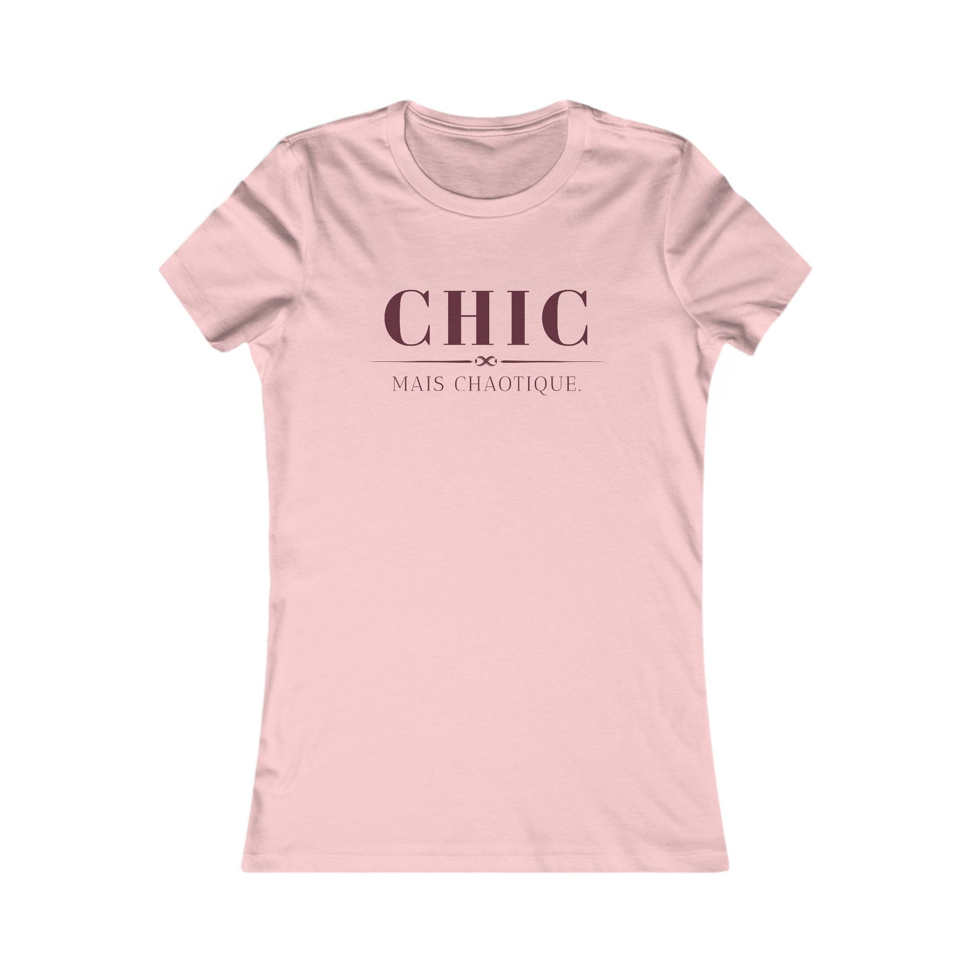 A light pink short-sleeve crewneck t-shirt with the French phrase 'CHIC MAIS CHAOTIQUE' printed in dark pink on the chest, displayed on a clean white background.