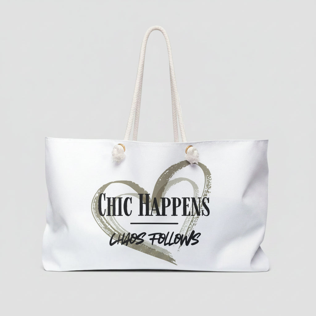 A white canvas tote bag with white rope handles, featuring a printed graphic of a textured heart and the text 'Chic Happens' and 'Chaos Follows' on the front.