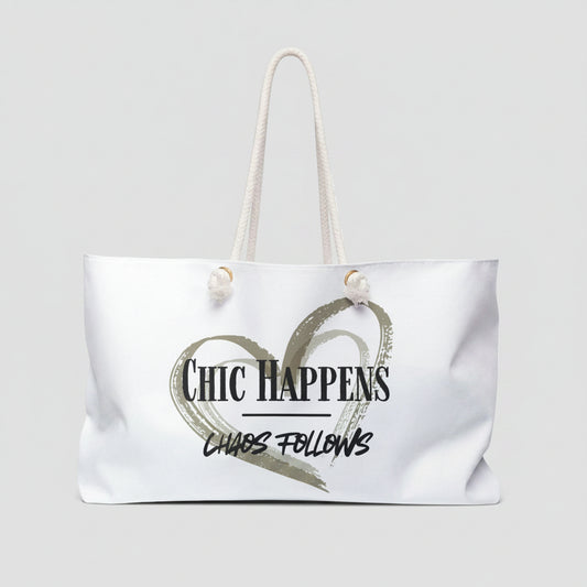 A white canvas tote bag with white rope handles, featuring a printed graphic of a textured heart and the text 'Chic Happens' and 'Chaos Follows' on the front.