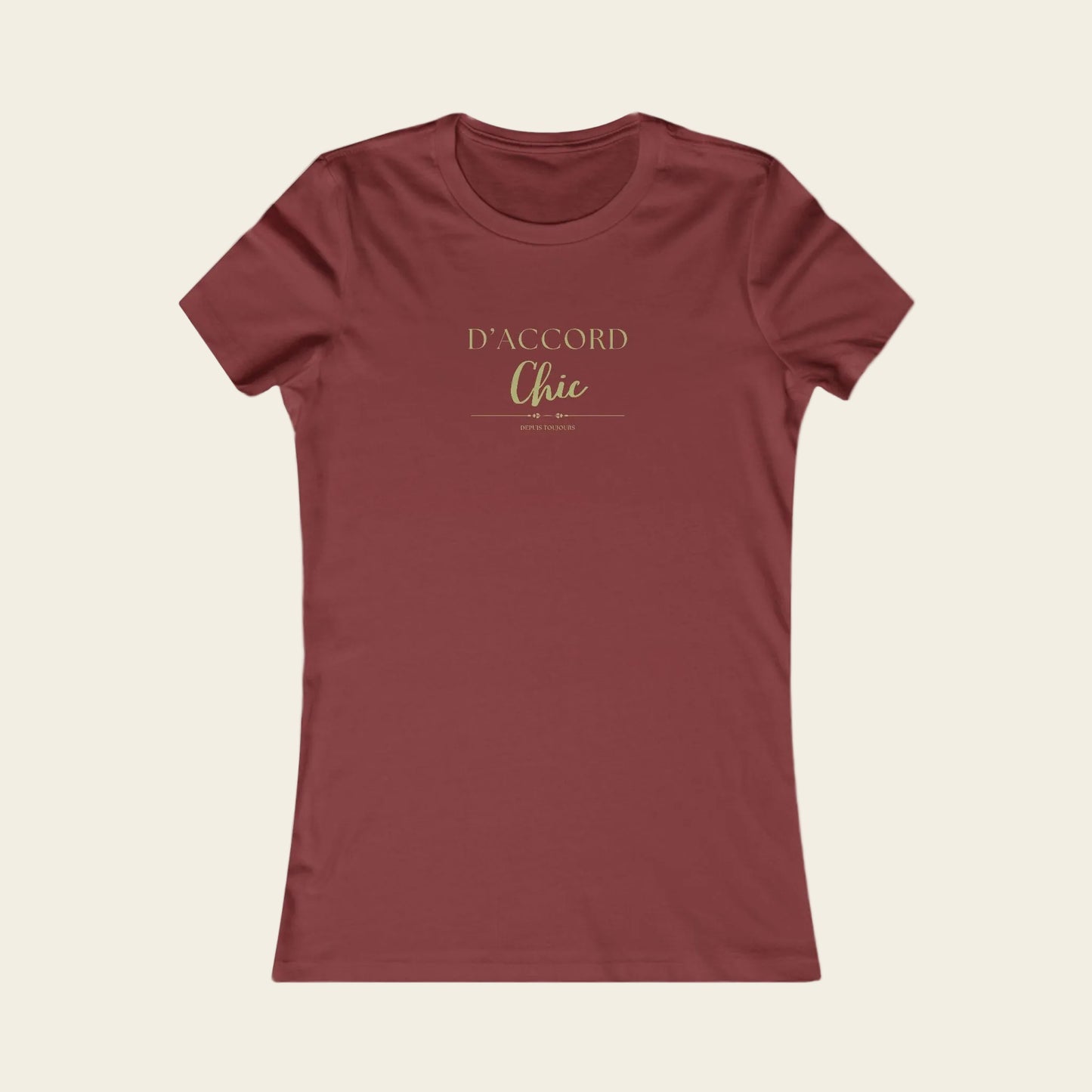 A women's short-sleeve crewneck t-shirt in a muted brick red color, featuring the text 'D'ACCORD Chic' printed in a gold metallic-style font on the chest, displayed against background.
