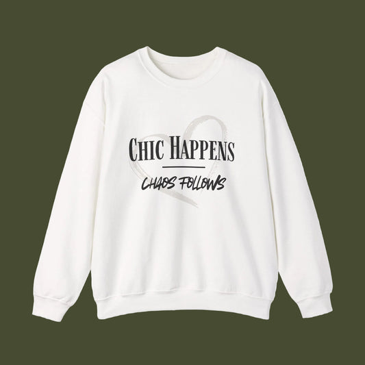 An off-white crewneck sweatshirt with a black graphic print on the front reading 'CHIC HAPPENS' and 'CHAOS FOLLOWS' with a faint heart outline, displayed on a clean white background.