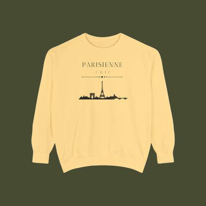 A pale yellow crewneck sweatshirt featuring a black graphic print of the Paris skyline with the text 'PARISIENNE CHIC' above it, displayed on a clean white background.