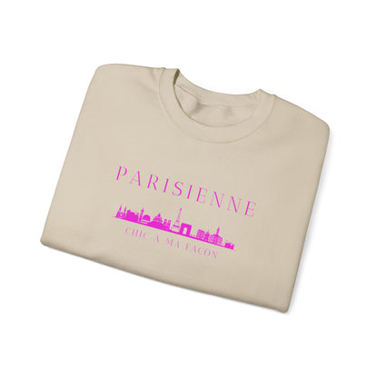 A folded beige crewneck sweatshirt with a bright pink “PARISIENNE” graphic, Paris skyline design, and “CHIC À MA FAÇON” text on the chest, displayed against a clean white background.