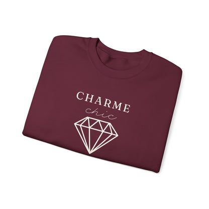 A folded maroon crewneck sweatshirt featuring a light graphic print that reads 'CHARME chic' above a diamond outline, set against a plain white background.
