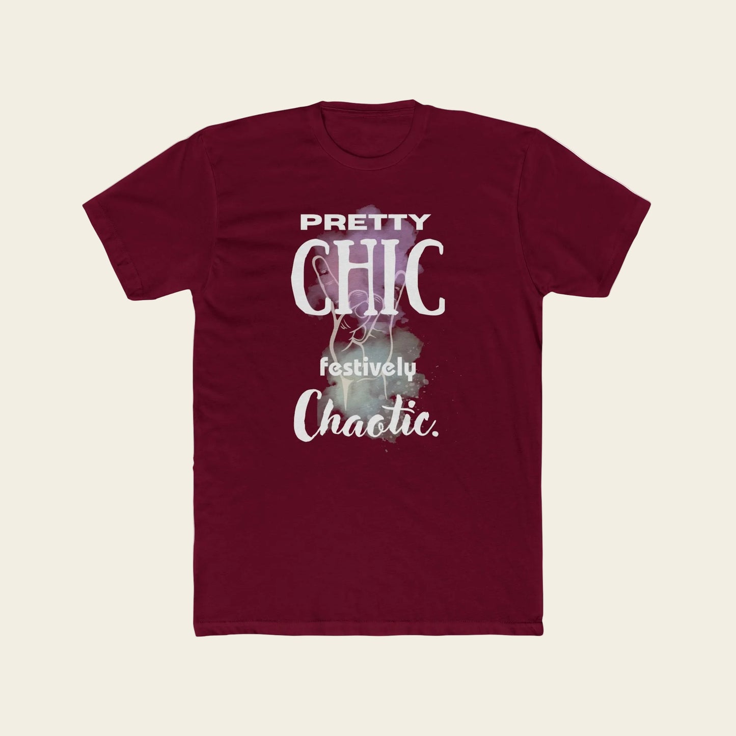 A maroon short-sleeve crewneck t-shirt with a graphic print on the front that reads 'PRETTY CHIC festively Chaotic.' in white and light purple text over a faint festive illustration.