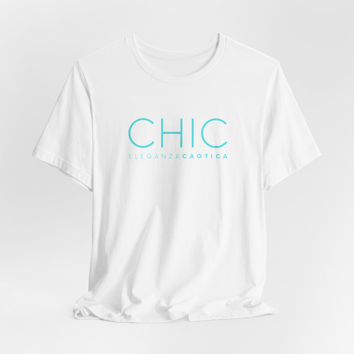A white short-sleeve crewneck T-shirt with 'CHIC' printed in light blue sans-serif typography and 'ELEGANZA CAOTICA' in smaller text underneath, shown against a light gray gradient studio background.