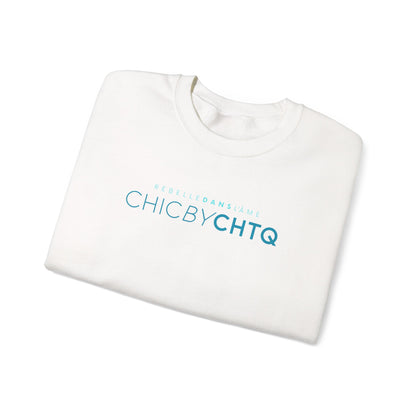 A white crewneck sweatshirt with text reading “CHIC BY CHTQ” and “REBELLE DANS L’ÂME” printed across the chest.