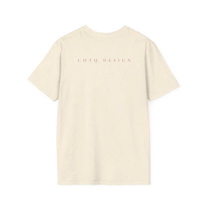 A cream colored crewneck T-shirt from back with pink “CHTQ DESIGN” and “MORE THAN A SHIRT, IT’S A MOVEMENT” text on the front, paired with black pants against a plain white background.