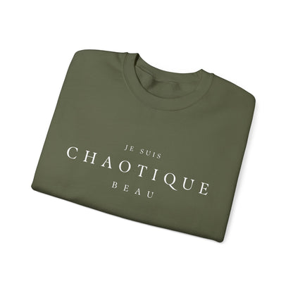 Folded  green crewneck sweatshirt with the text 'JE SUIS CHAOTIQUE BEAU' printed in white across the chest