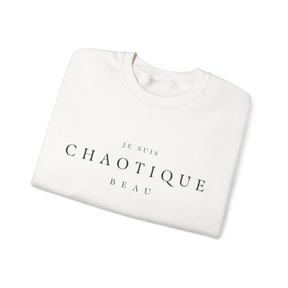 Folded off-white crewneck sweatshirt with 'JE SUIS CHAOTIQUE BEAU' printed in black serif text on the chest, displayed on a clean white background.