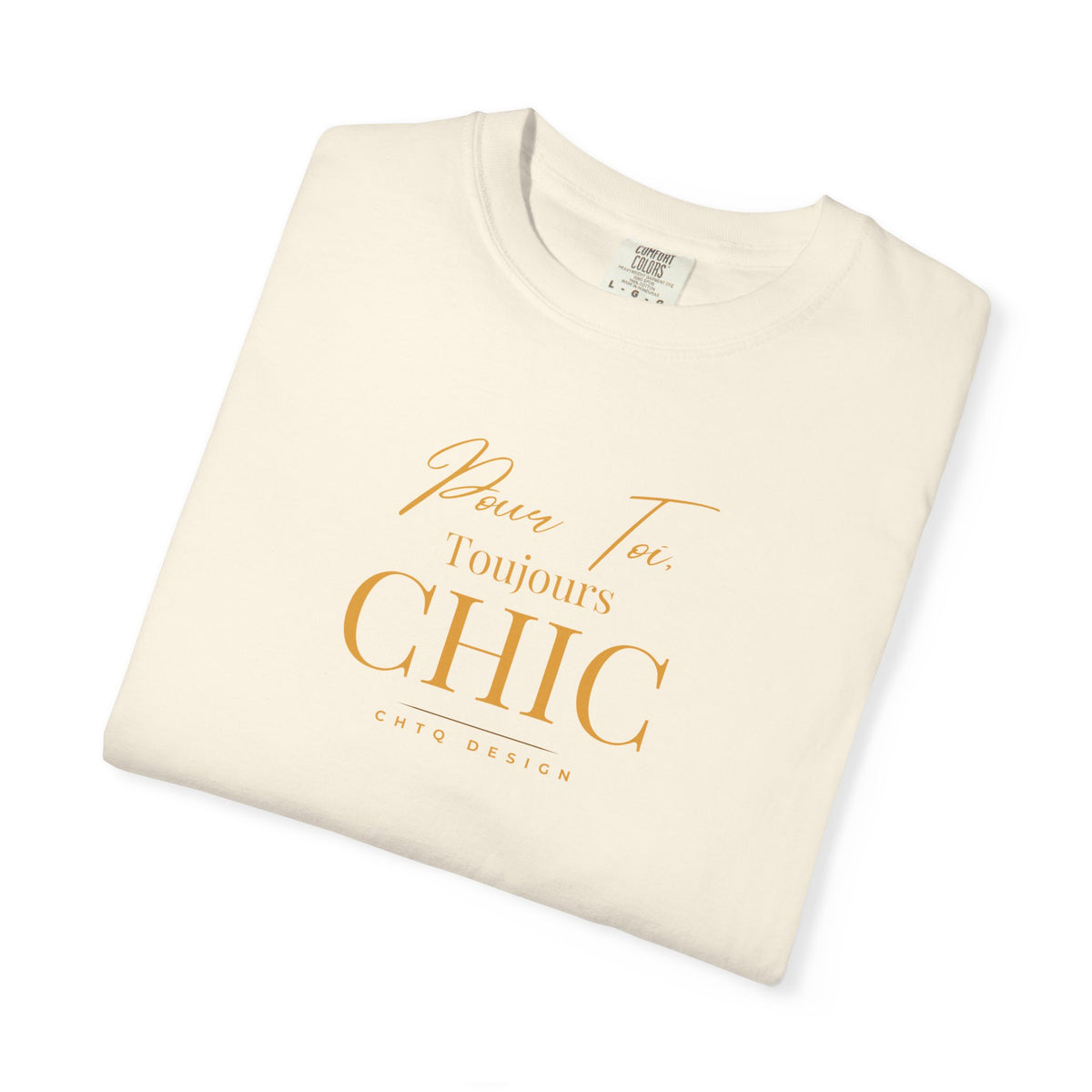Folded cream CHTQ Design T-shirt with gold “Pour Toi. Toujours CHIC” typography on the front.