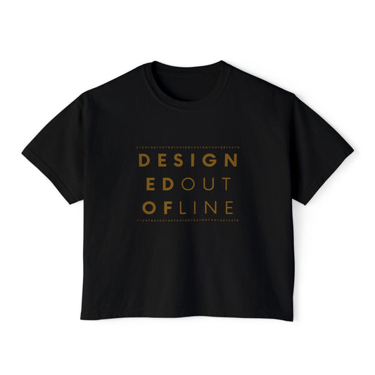 A black short-sleeve boxy T-shirt with a slightly cropped fit and a gold typography graphic on the front reading “DESIGNED OUT OF LINE.”