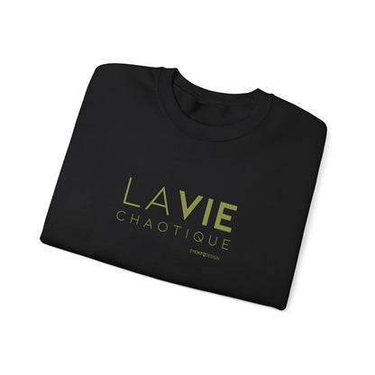 Folded black crewneck sweatshirt with “LA VIE CHAOTIQUE” printed in olive green and “BY CHTQ DESIGN” beneath the graphic, displayed against a clean white background.