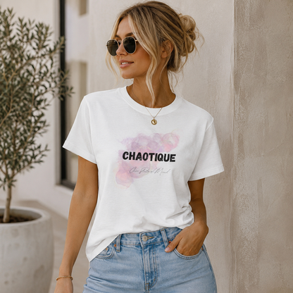 Woman wearing a white t-shirt with 'CHAOTIQUE chic state of mind' design and sunglasses, standing against a neutral wall.