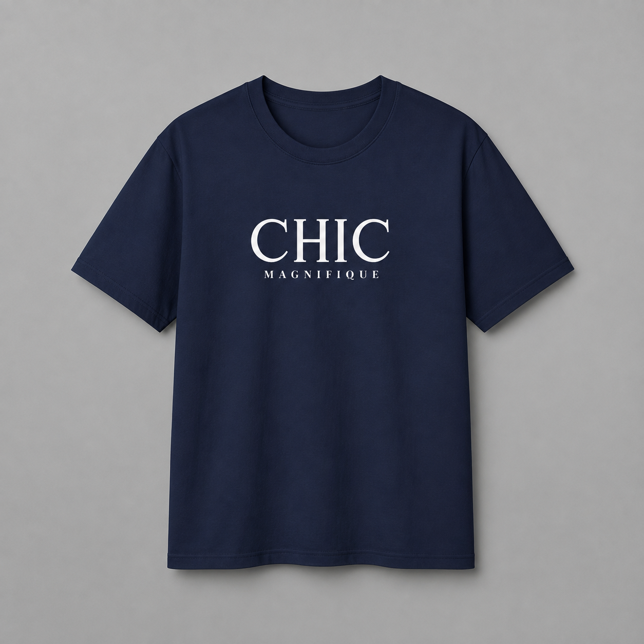 Navy blue CHIC MAGNIFIQUE graphic T-shirt featuring minimalist white French-inspired typography on the chest, displayed against a clean light gray studio background.