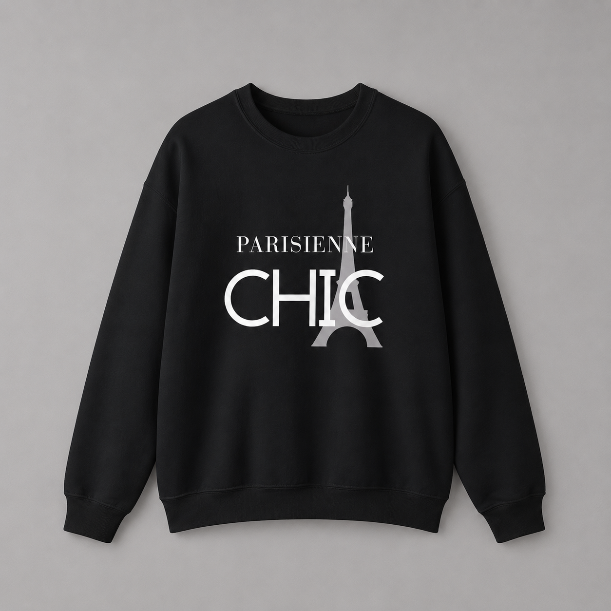 Black crewneck sweatshirt featuring a white “PARISIENNE CHIC” graphic with a stylized Eiffel Tower, displayed against a neutral gray studio background.
