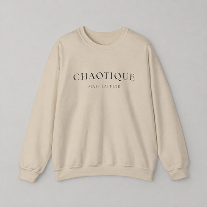 Cream color sweatshirt on a white background featuring a “Chaotique Mais Raffiné” graphic text print.