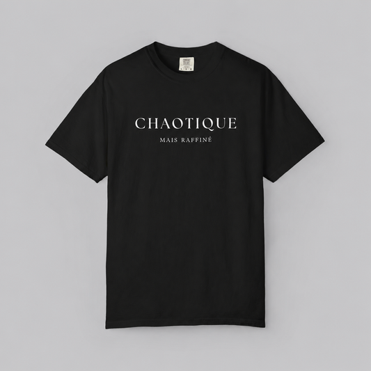 A black short-sleeve crewneck t-shirt with 'CHAOTIQUE MAIS RAFFINE' printed in white serif text across the chest, displayed flat against a neutral gray background.