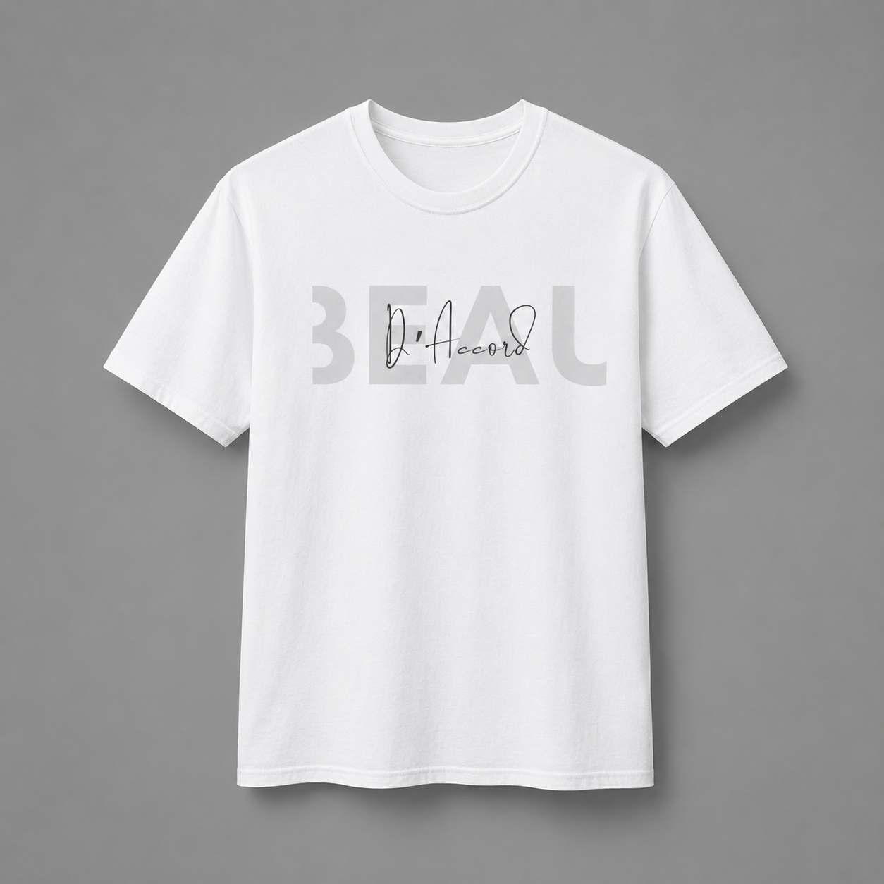 White short-sleeve crewneck T-shirt featuring a gray “BEAU” graphic with a white cursive “D’Accord” overlay, displayed against a neutral gray studio background.