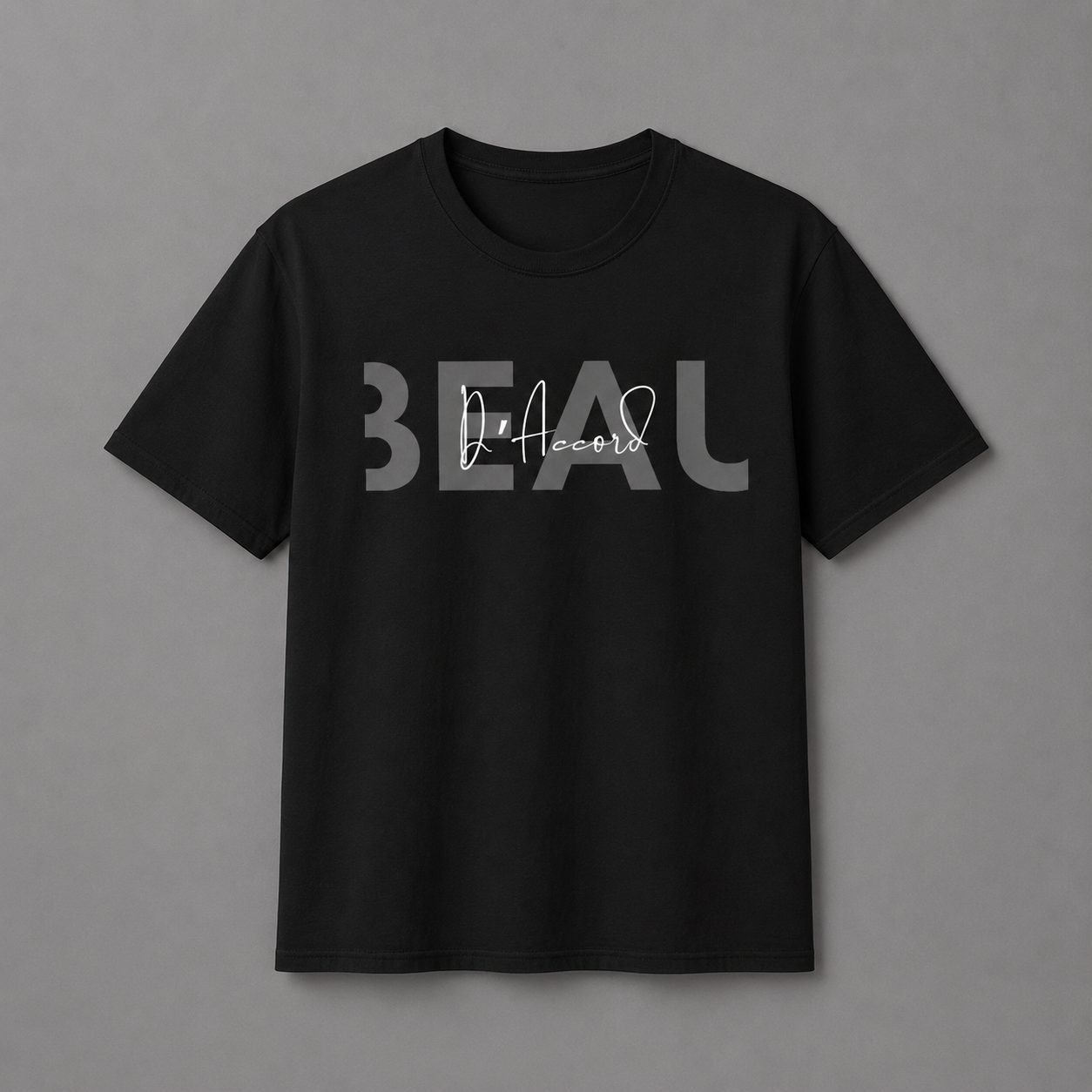 Black short-sleeve crewneck T-shirt featuring a gray “BEAU” graphic with a white cursive “D’Accord” overlay, displayed against a neutral gray studio background.
