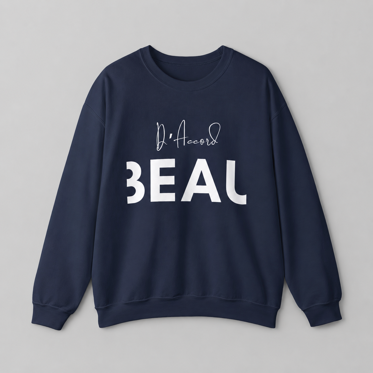 A navy blue crewneck sweatshirt featuring a black “D’accord” script graphic above bold “BEAU” lettering across the chest, displayed against a neutral light gray background.