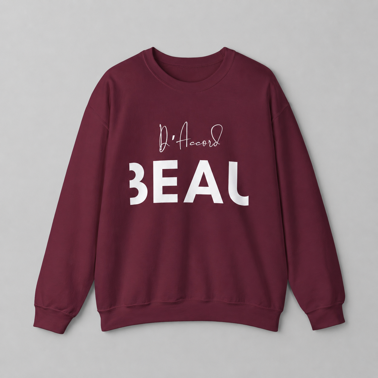  A maroon crewneck sweatshirt featuring a black “D’accord” script graphic above bold “BEAU” lettering across the chest, displayed against a neutral light gray background.
