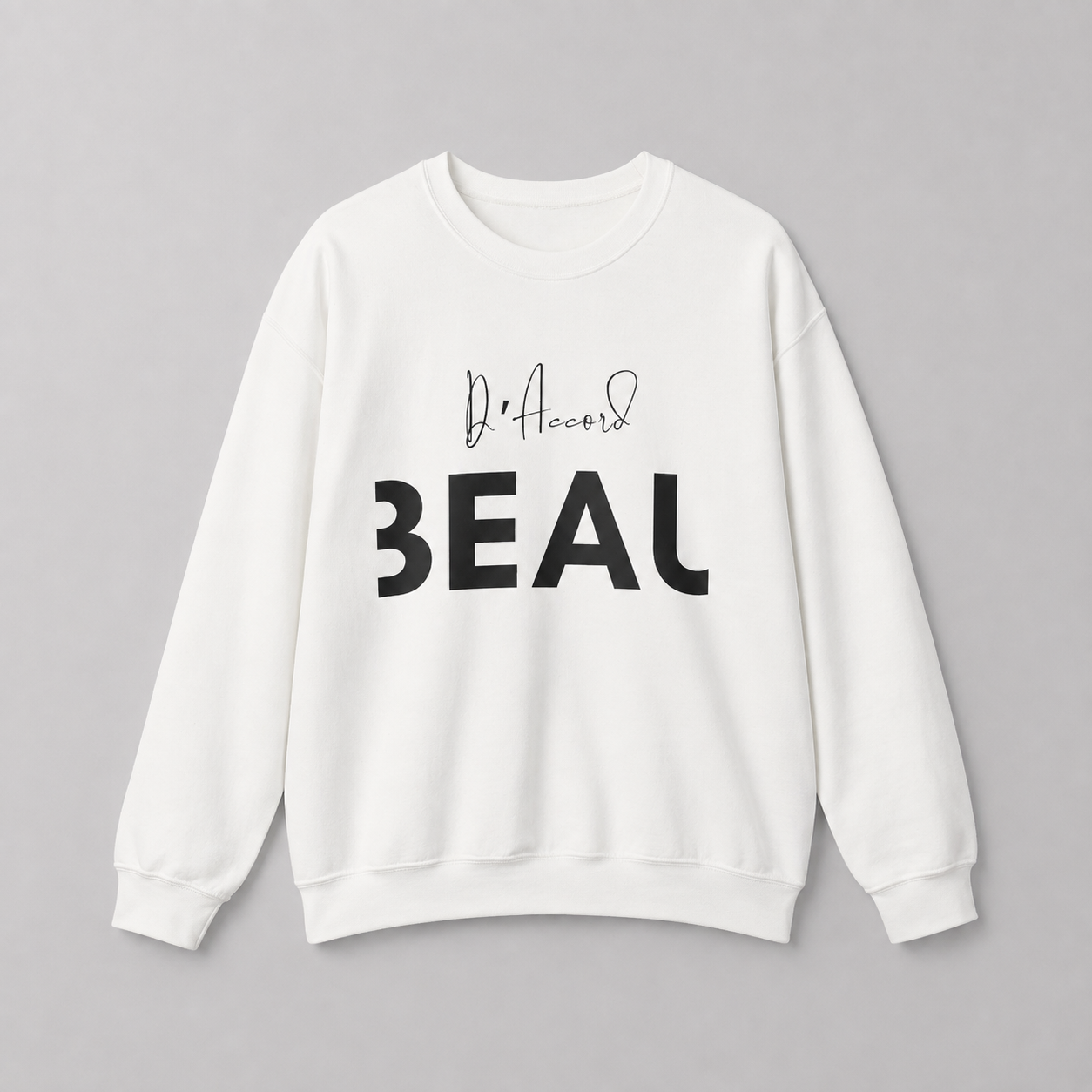 A white crewneck sweatshirt featuring a black “D’accord” script graphic above bold “BEAU” lettering across the chest, displayed against a neutral light gray background.