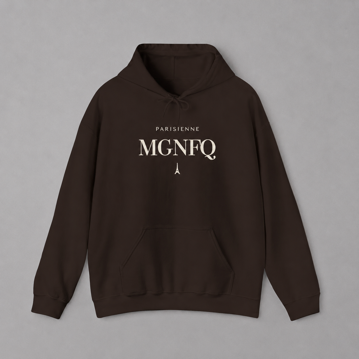 Brown PARISIENNE MGNFQ graphic hoodie featuring cream typography and a small Eiffel Tower detail, shown against a light gray studio background.