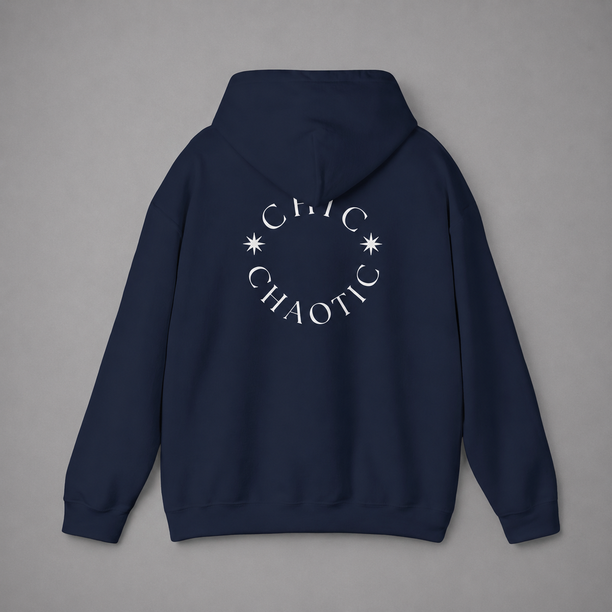Navy blue pullover hoodie shown from the back, featuring a dark burgundy circular CHIC CHAOTIC graphic with subtle star accents against a neutral gray studio background.