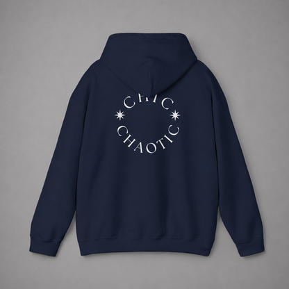 Navy blue pullover hoodie shown from the back, featuring a dark burgundy circular CHIC CHAOTIC graphic with subtle star accents against a neutral gray studio background.