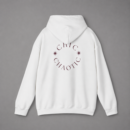 White pullover hoodie shown from the back, featuring a dark burgundy circular CHIC CHAOTIC graphic with subtle star accents against a neutral gray studio background.