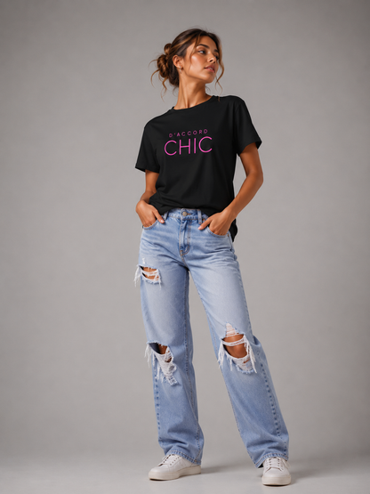Woman wearing a black D’Accord Chic graphic T-shirt with bold pink typography in a modern studio setting.