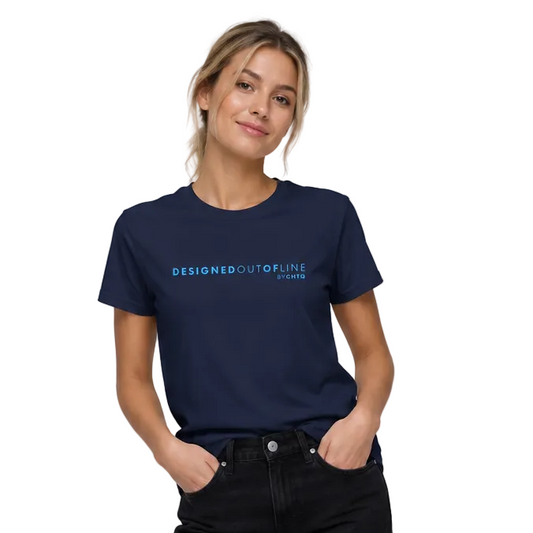 A woman modeling a navy blue crewneck T-shirt with light blue text that reads “DESIGNED OUT OF LINE” and “BY CHTQ” on the chest, paired with black jeans and white sneakers, against a light gray studio background.