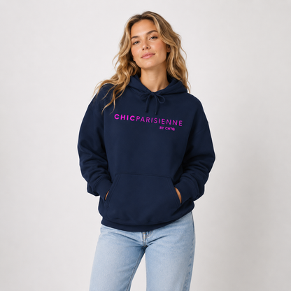 Woman wearing a navy blue CHIC PARISIENNE BY CHTQ graphic hoodie with bright pink lettering, paired with light-wash jeans in a light studio setting.