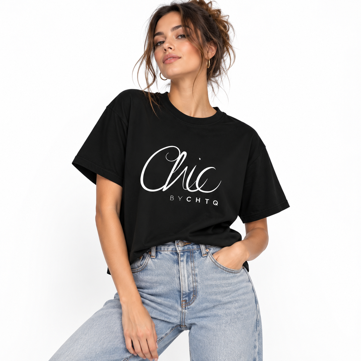 A woman wearing a black CHIC BY CHTQ cropped boxy T-shirt with a white script graphic on the front, paired with light-wash blue jeans, against a clean white studio background.