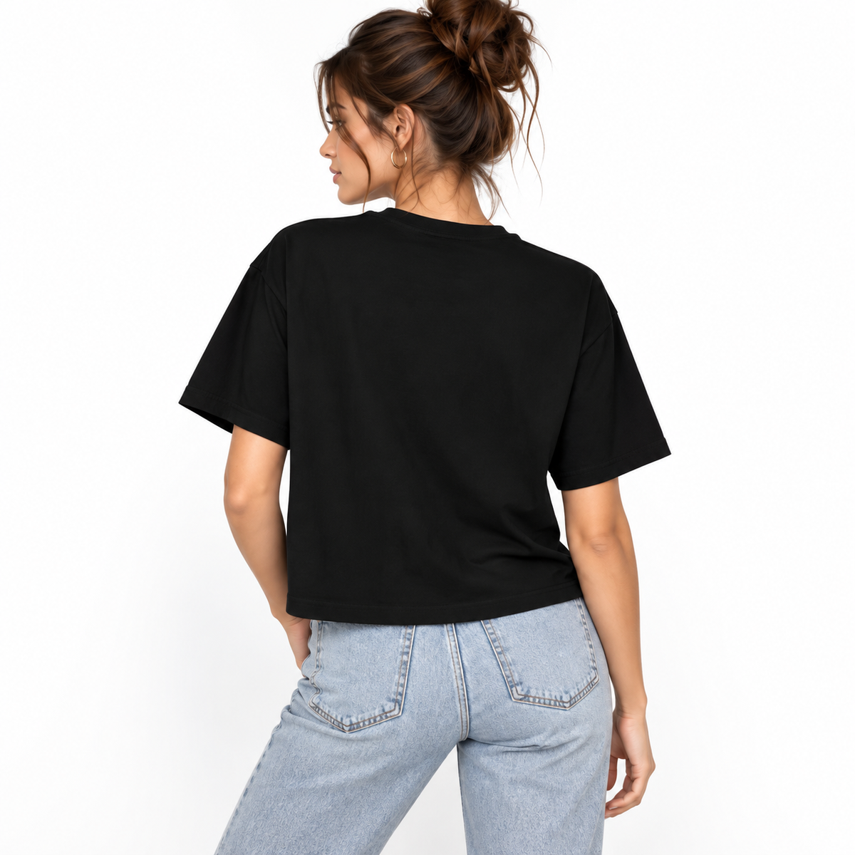 A woman wearing a black CHIC BY CHTQ cropped boxy T-shirt with a white script graphic on the front, paired with light-wash blue jeans, against a clean white studio background.