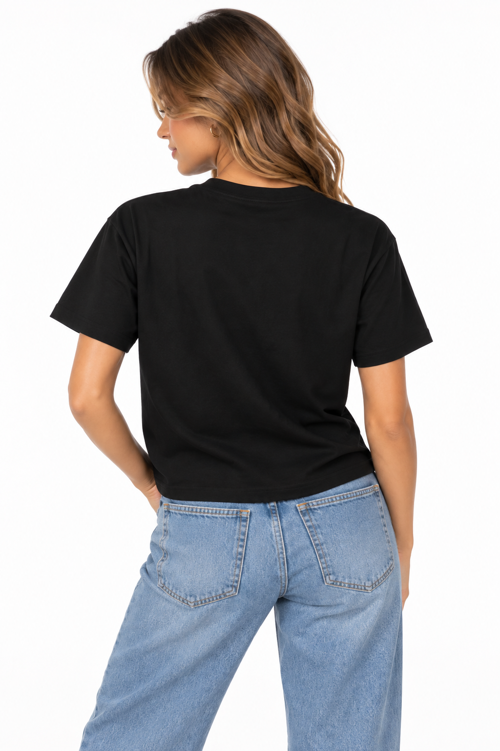 A woman shown from the back wearing a black boxy T-shirt with BEAUTIFULLY CHTQ design, paired with light blue high-waisted jeans against a clean white studio background.