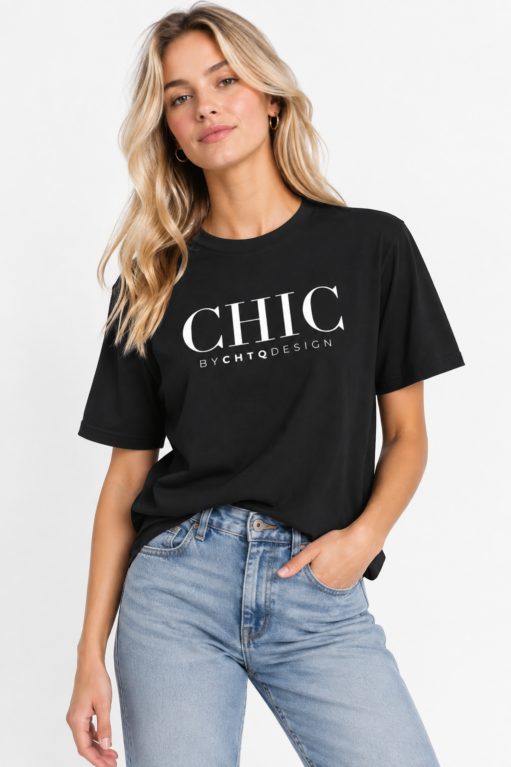 A woman wearing a black CHIC by CHTQ Design graphic T-shirt with white typography, paired with light blue jeans against a clean white studio background.