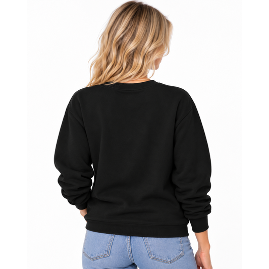 A woman viewed from the back wearing a black crewneck sweatshirt and light blue jeans against a plain white background.