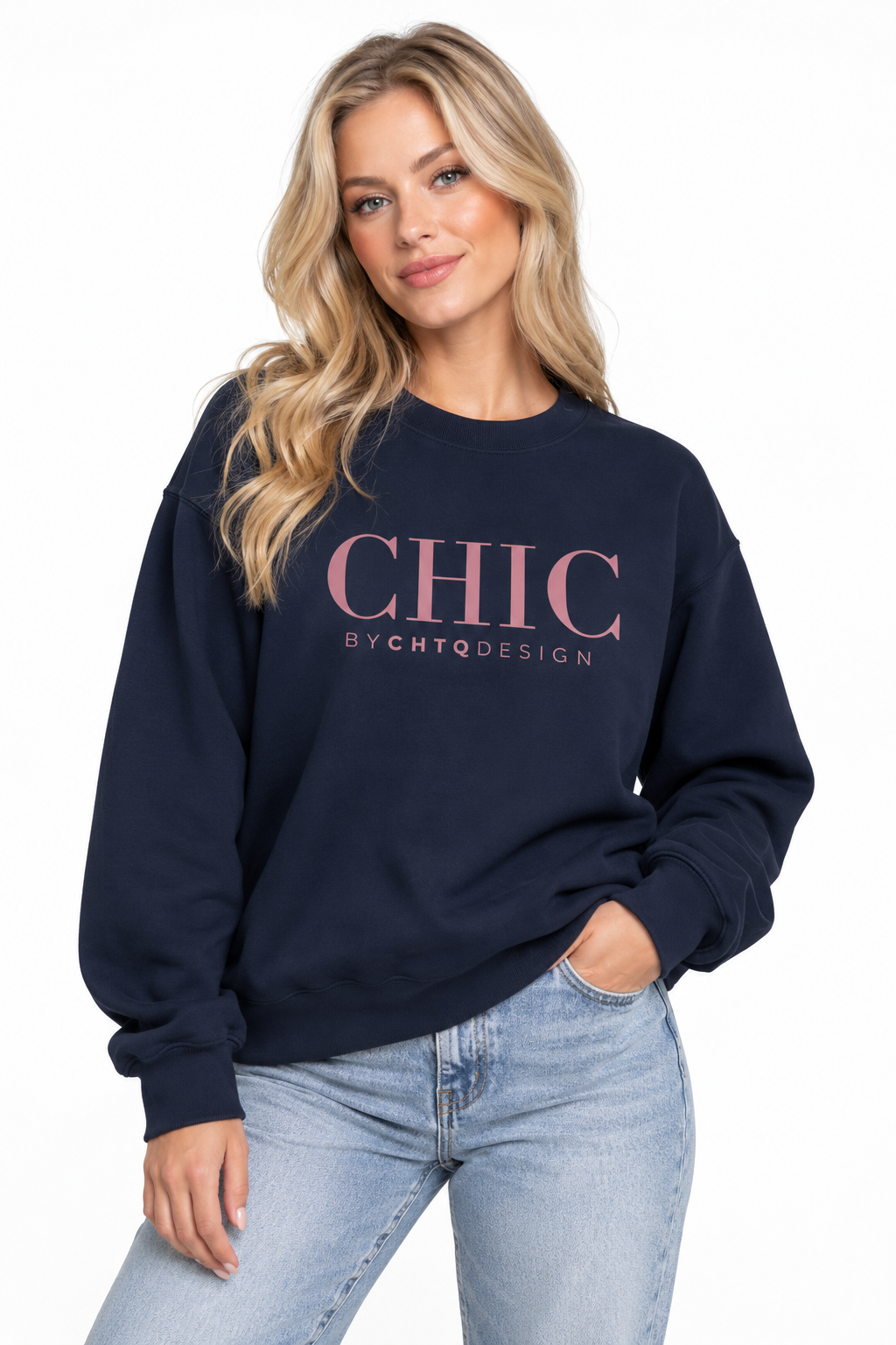 A woman wearing a navy blue CHIC BY CHTQ DESIGN Crewneck Sweatshirt with a pink graphic across the chest, paired with light-wash blue jeans against a clean white studio background.